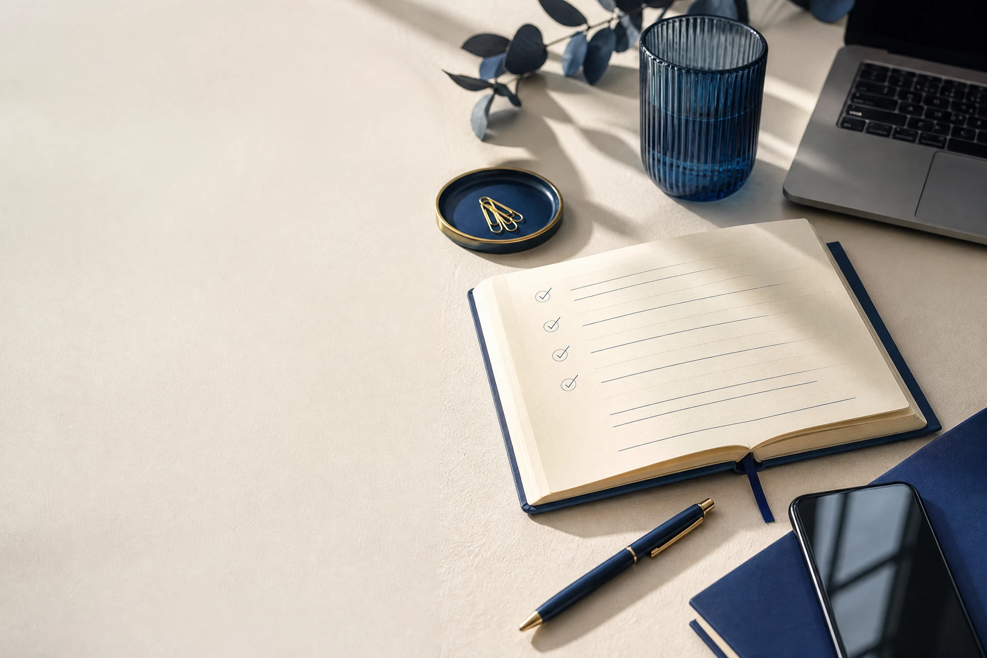 Mesa organizada com caderno, celular e materiais de trabalho